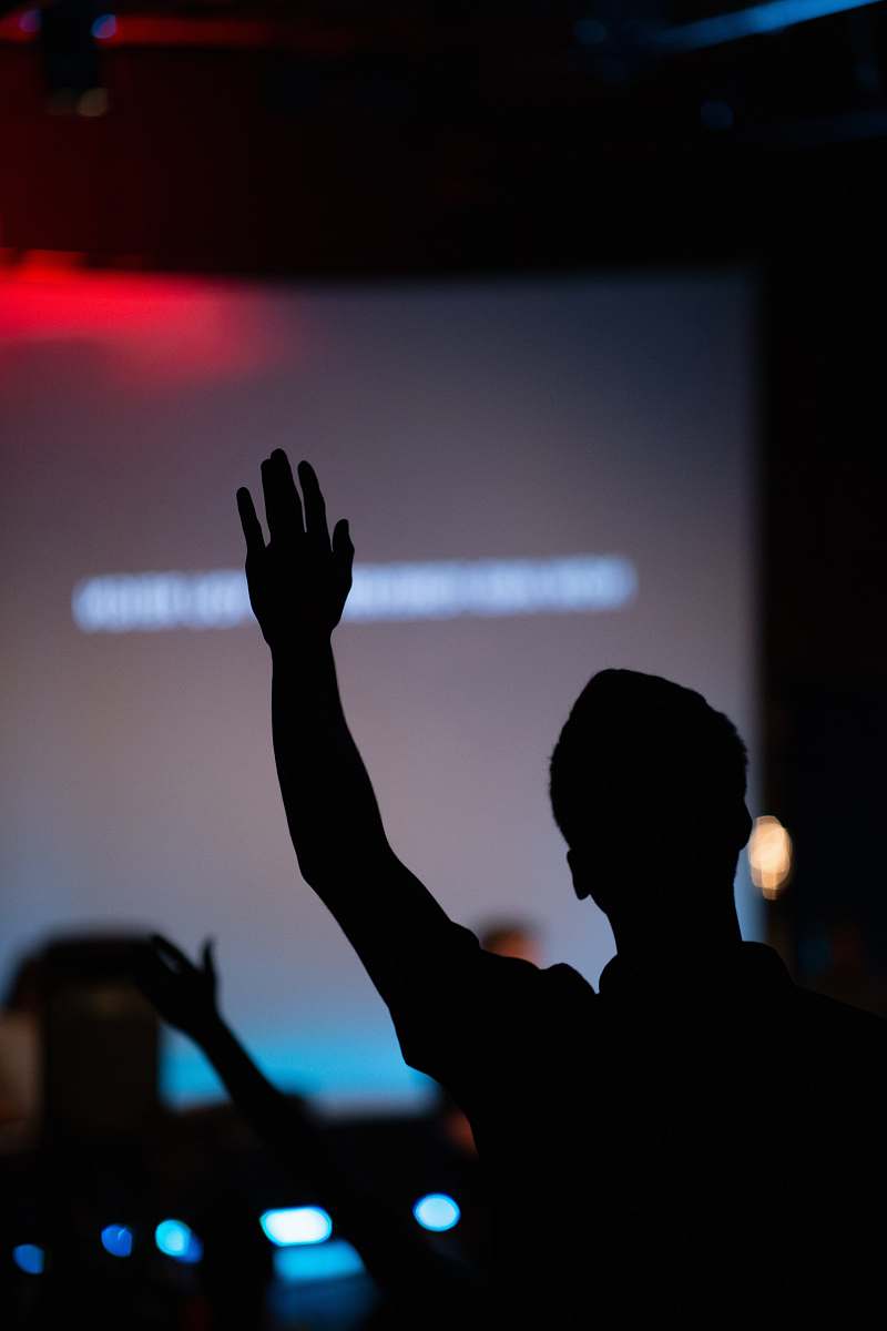 worship silhouette of person raising hand hand