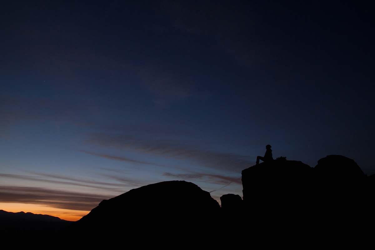 person silhouette of person sitting during sunset dusk