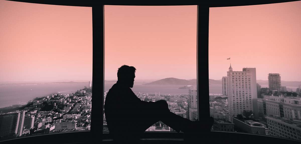 person silhouette of person sitting on building's window window