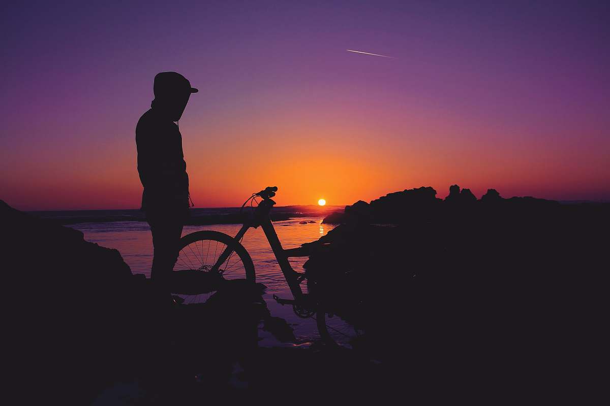 human silhouette of person standing near bicycle person