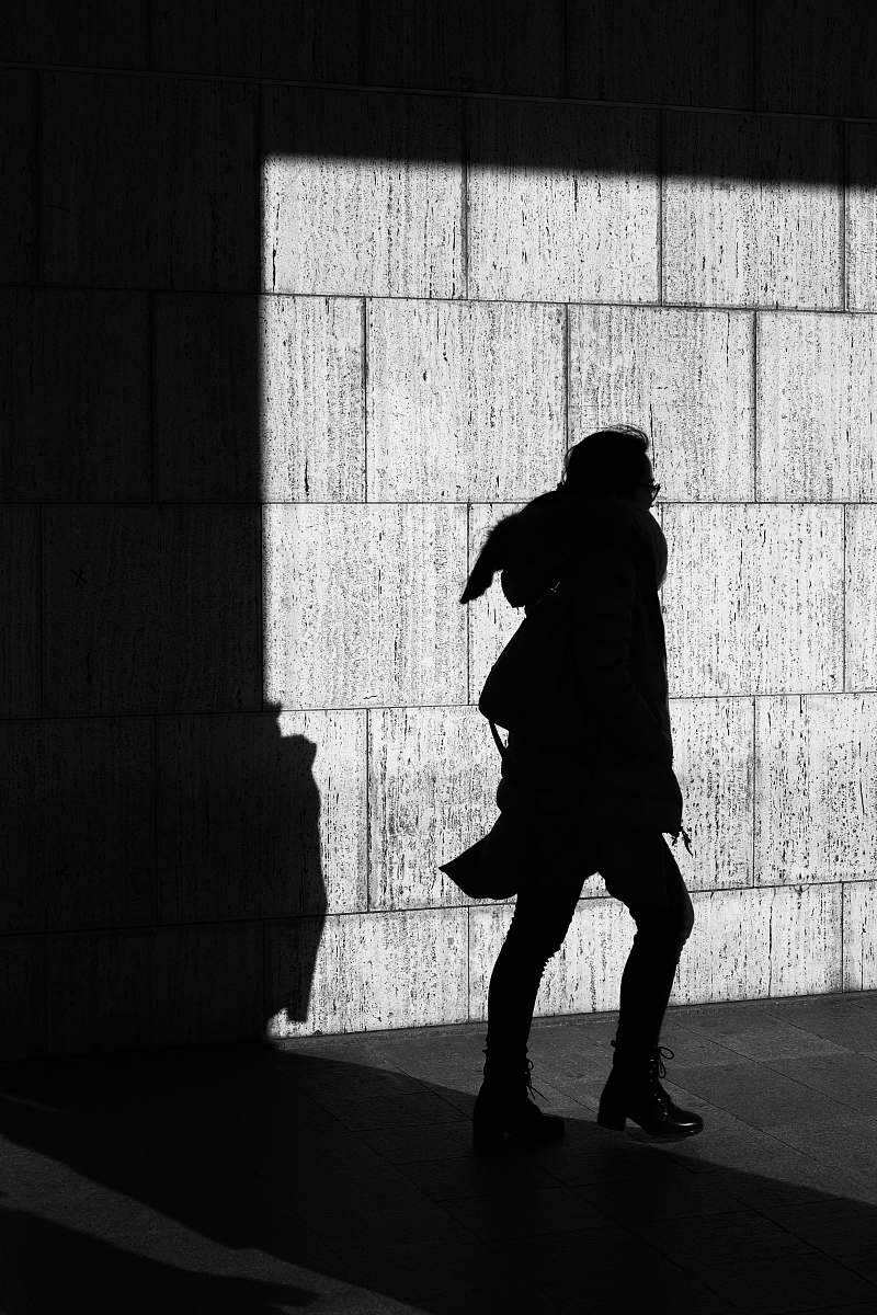 black-and-white silhouette of person standing near the wall wall