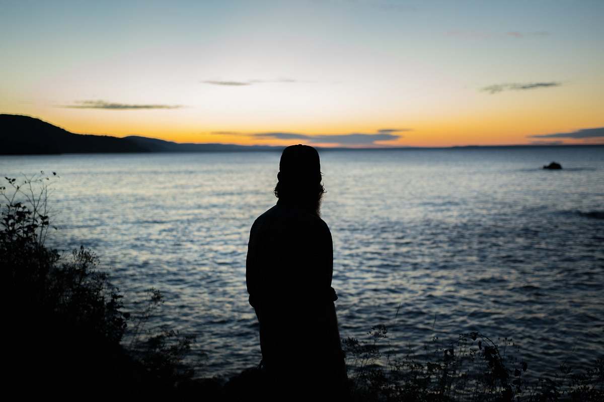 person silhouette of person standing near water human