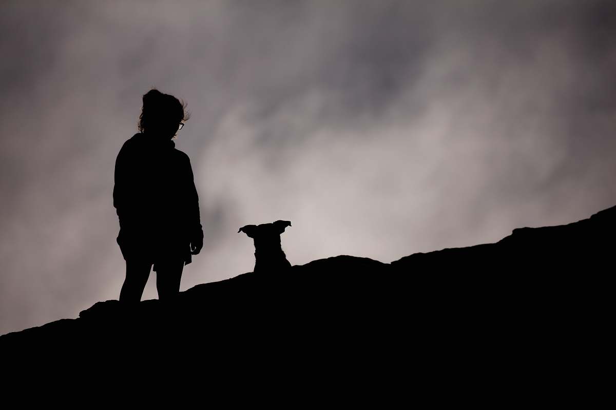 human silhouette of person standing on cliff person