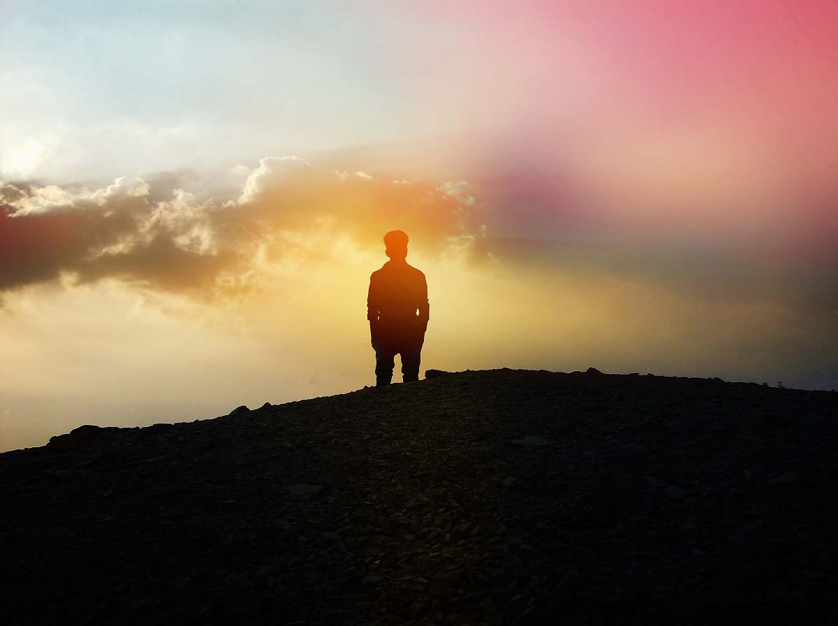 clouds silhouette of person standing on hill sunrise