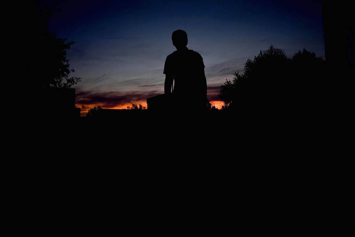 sunset silhouette of person standing under blue sky during sunet trees