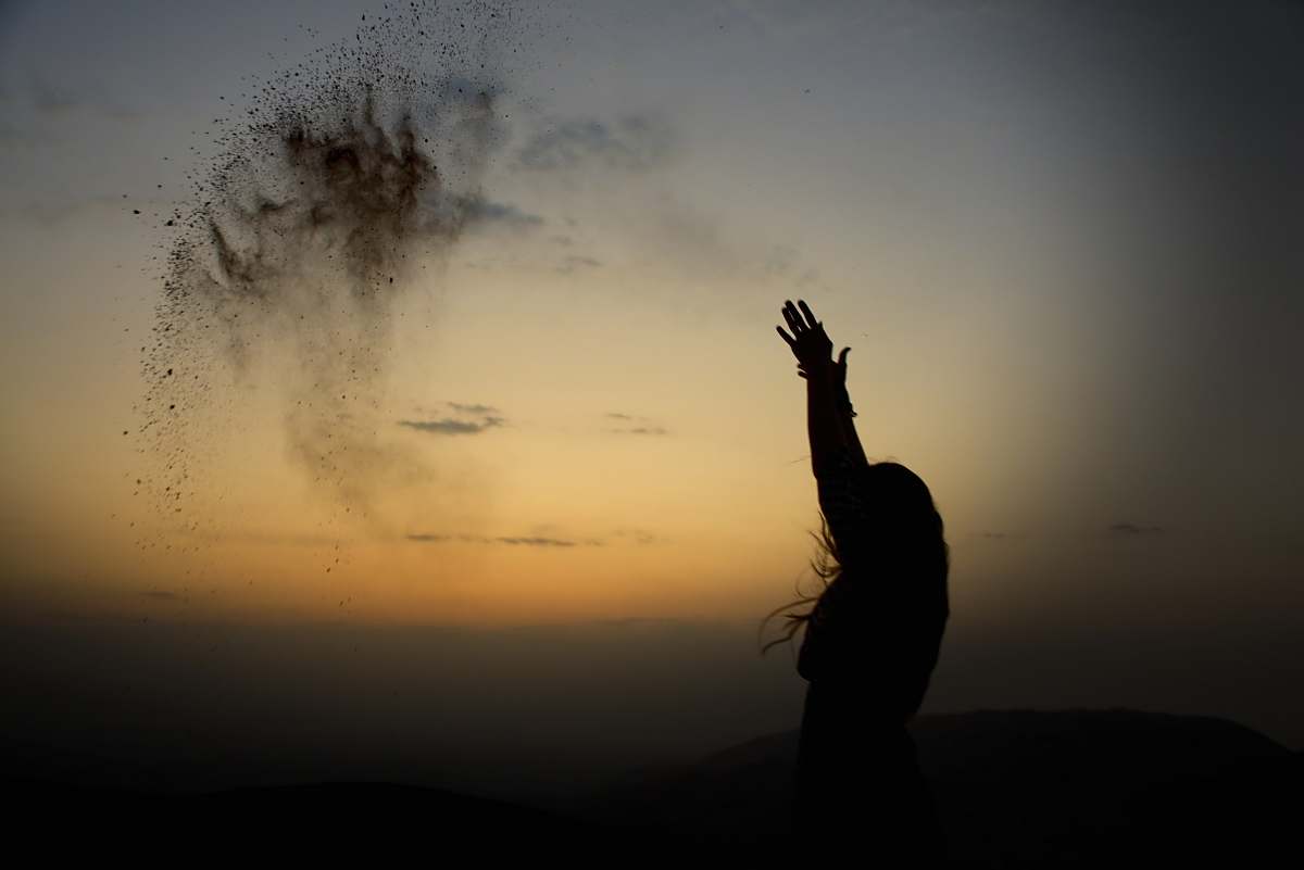 human silhouette of person throwing sands on air person
