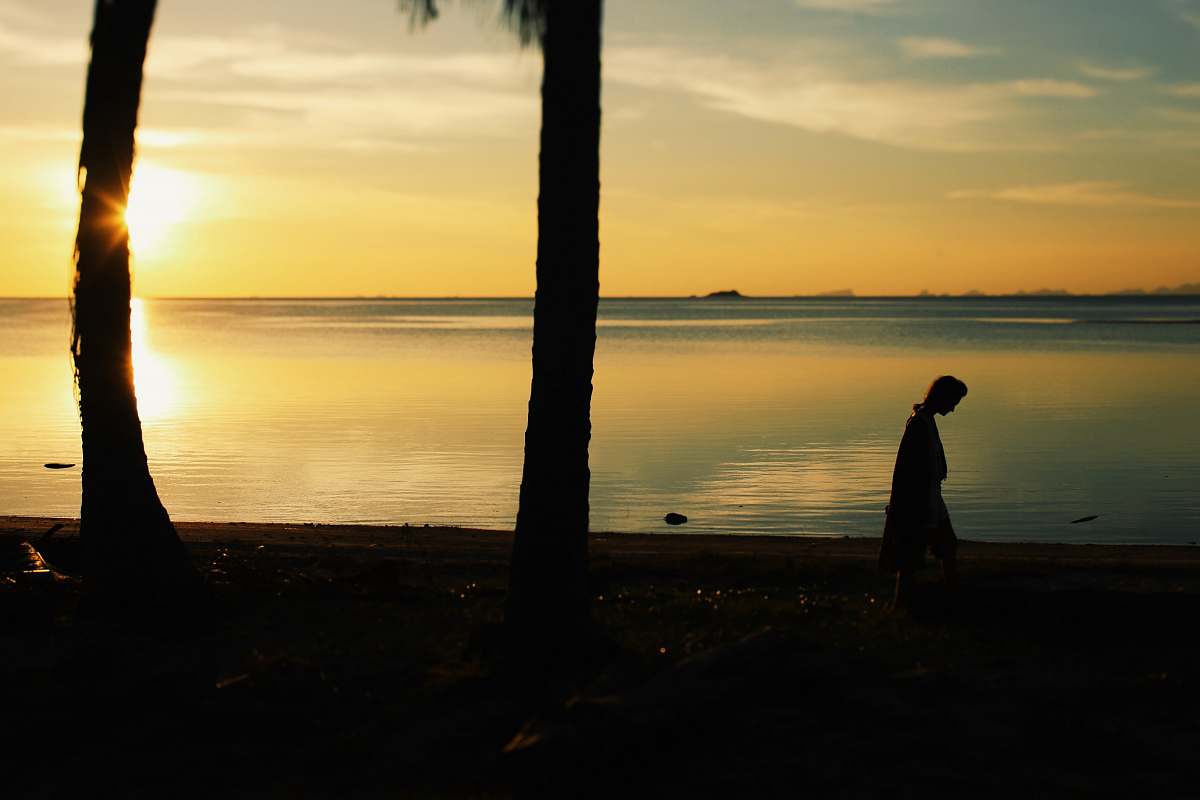 nature silhouette of person walking near body of water outdoors