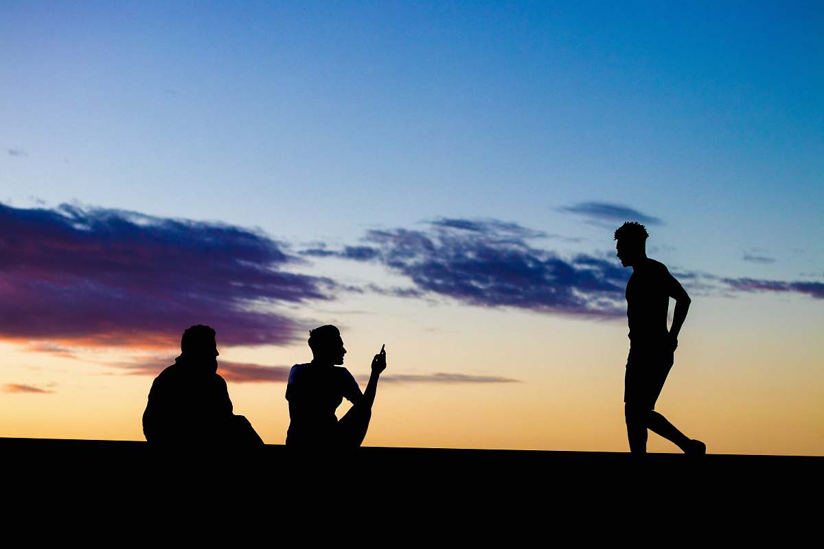 person silhouette of three persons under blue and orange skies human