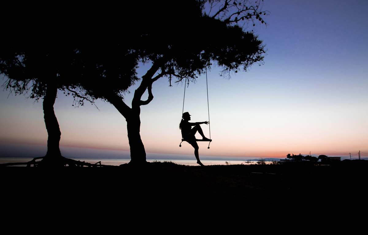 swing silhouette of tree near body of water greece
