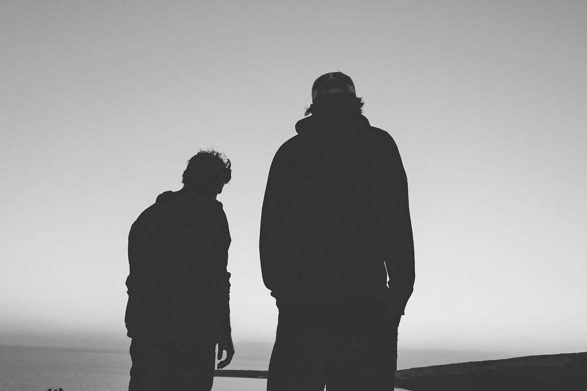 black-and-white silhouette of two man grey