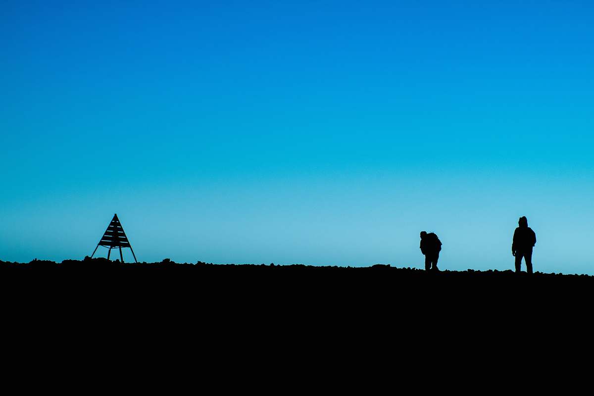 blue silhouette of two person standing on ground near tent at daytime morocco