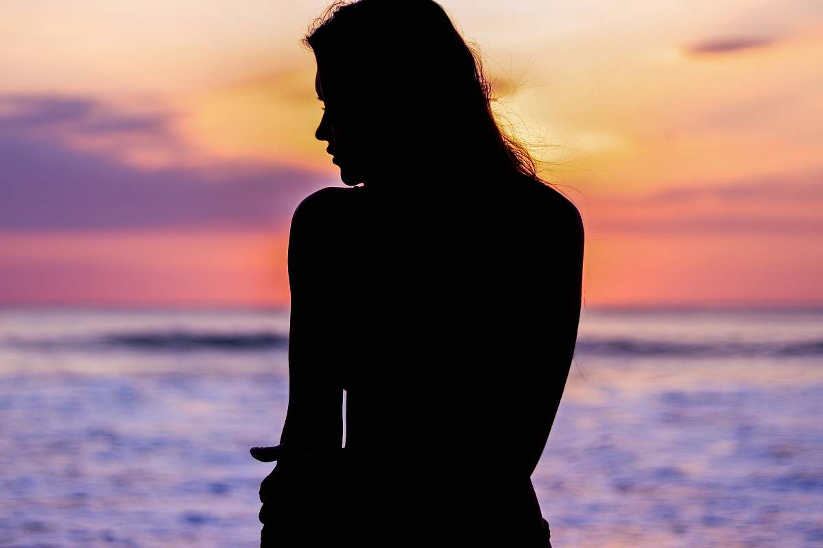 human silhouette of woman facing ocean person