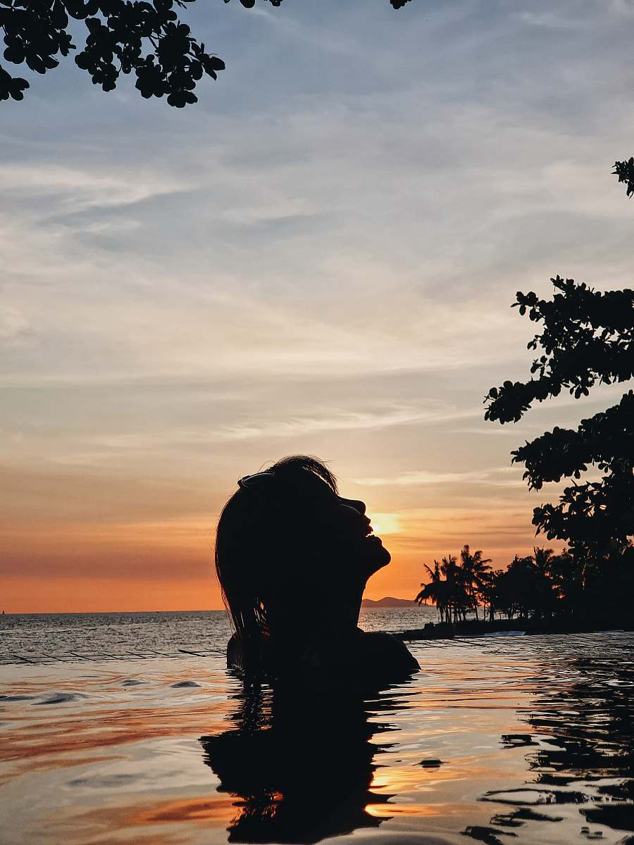 nature silhouette of woman in body of water during golden hour sunset