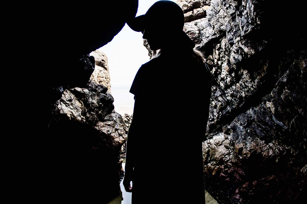 person silhouette of woman standing inside cave human