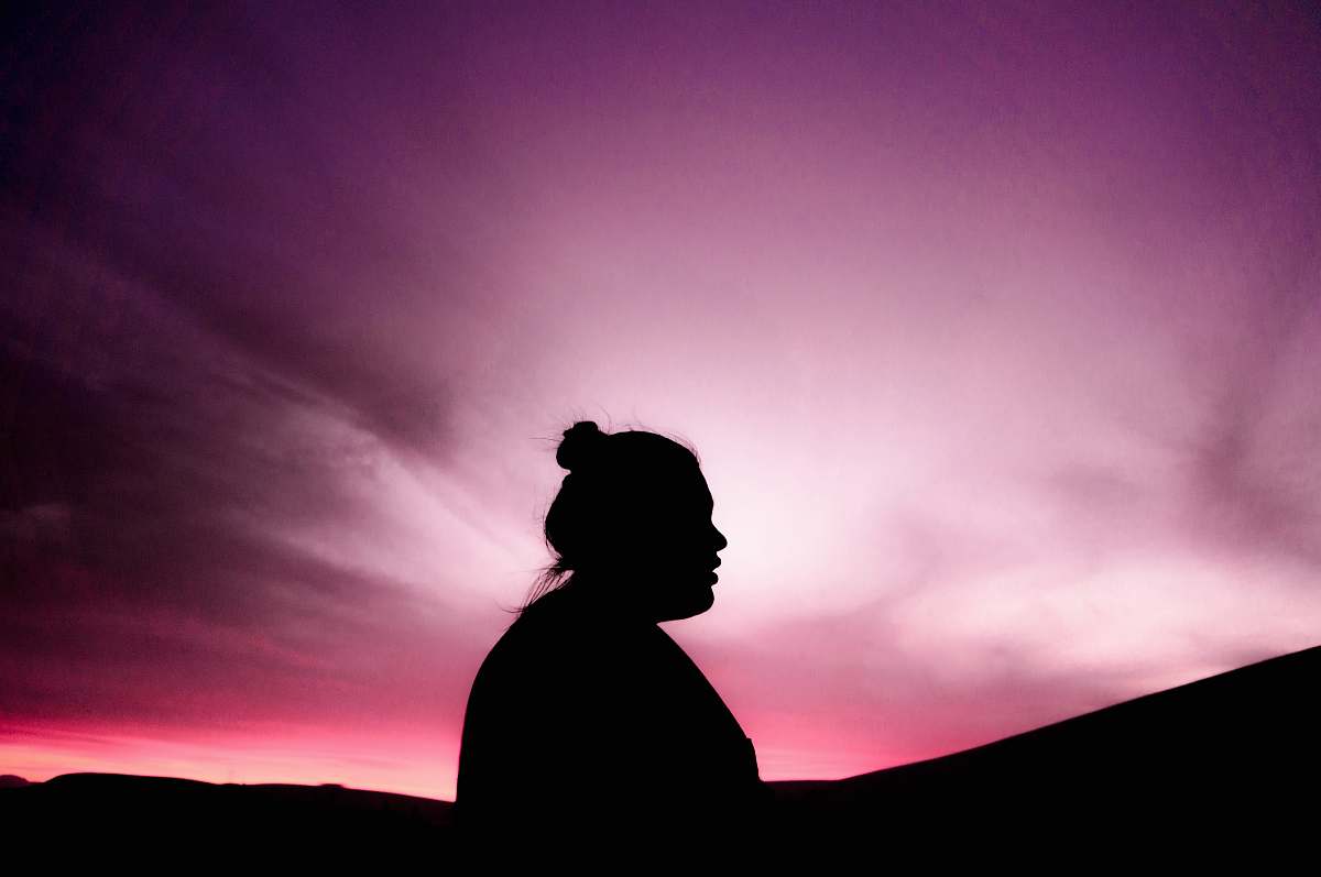 human silhouette of woman under purple sky person