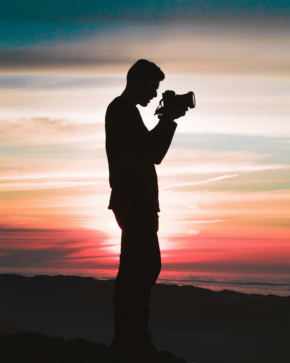 person silhouette photo of man holding camera human
