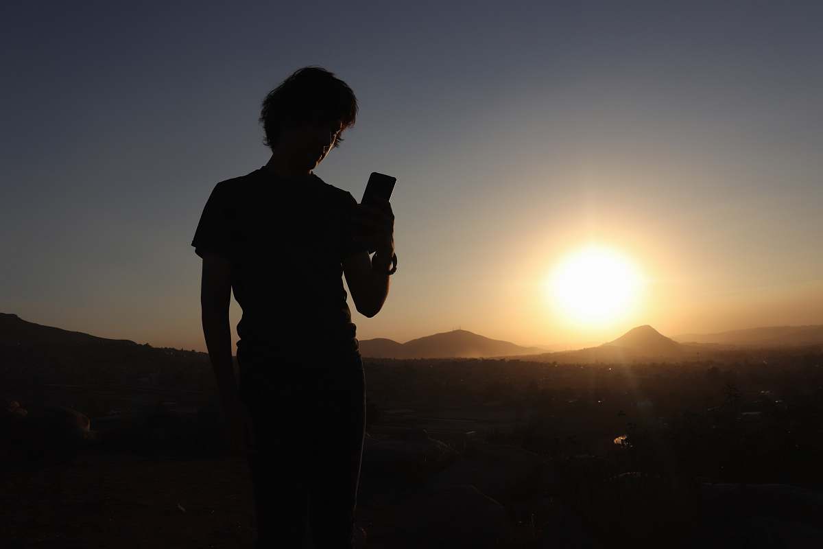 human silhouette photo of man holding phone person