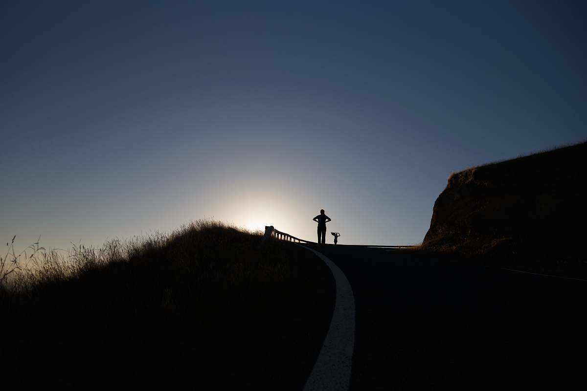 person silhouette photo of person above hill grass