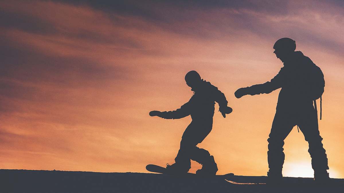 person silhouette photo of two person riding on snowboard people