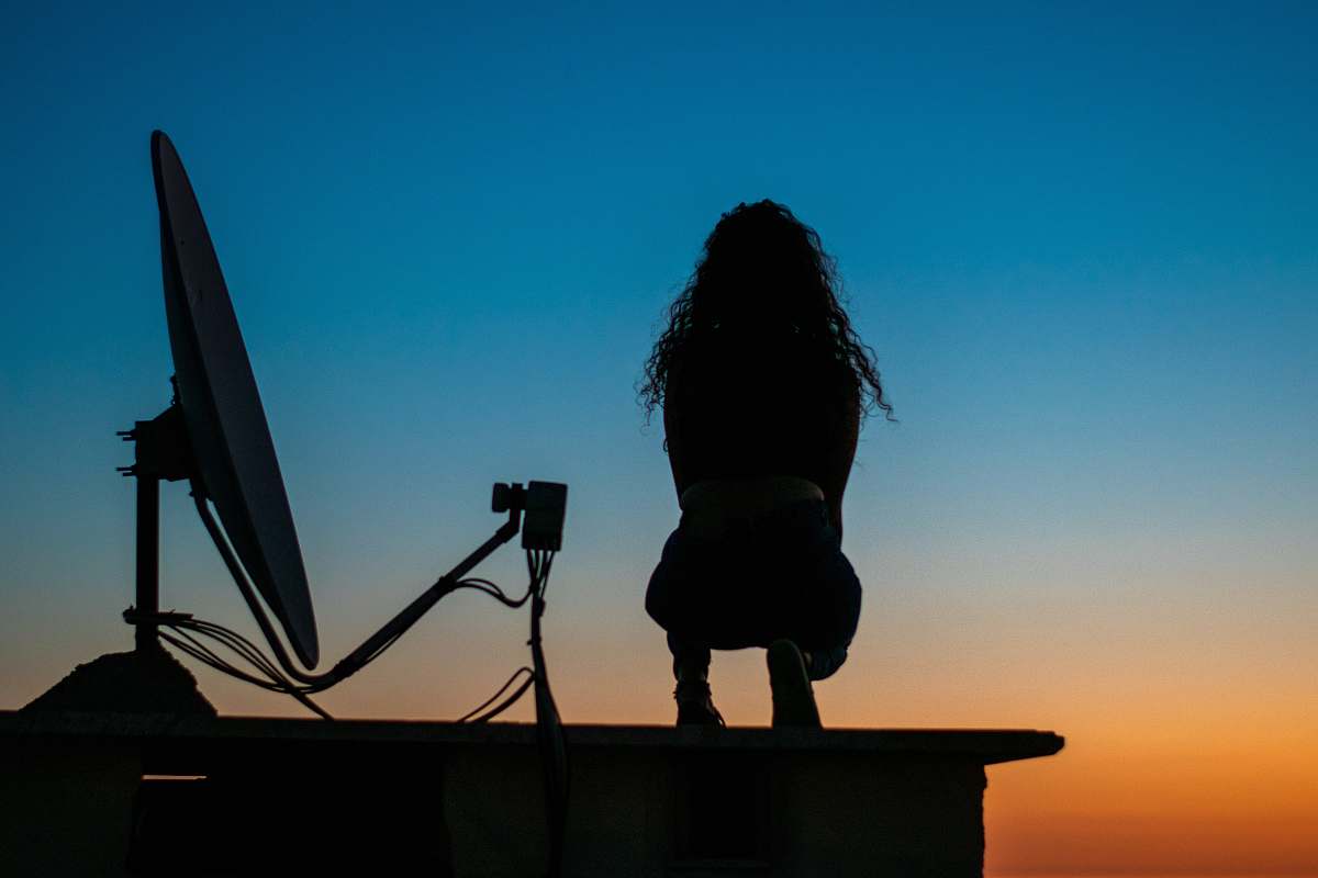 human silhouette photo of woman standing on top of building person