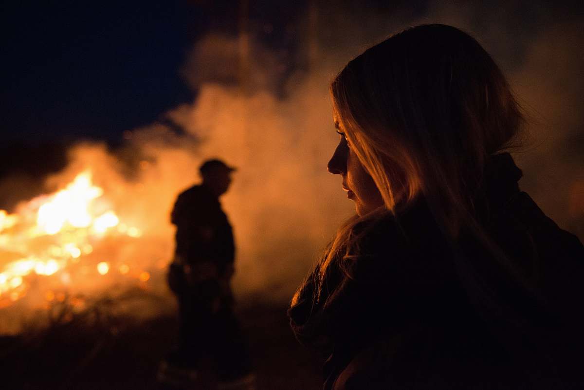 human silhouette photography of man and woman nearby bush fire person