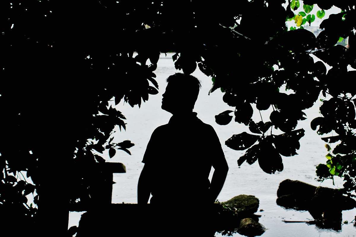 human silhouette photography of person beside tree person
