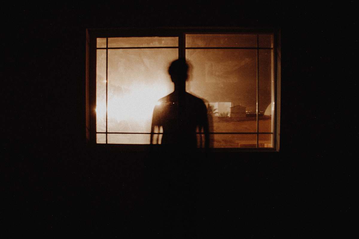 light silhouette photography of person in front of window window