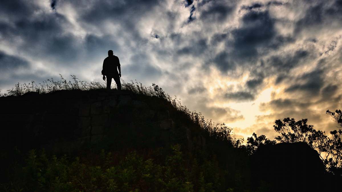 person silhouette photography of person standing on hill human