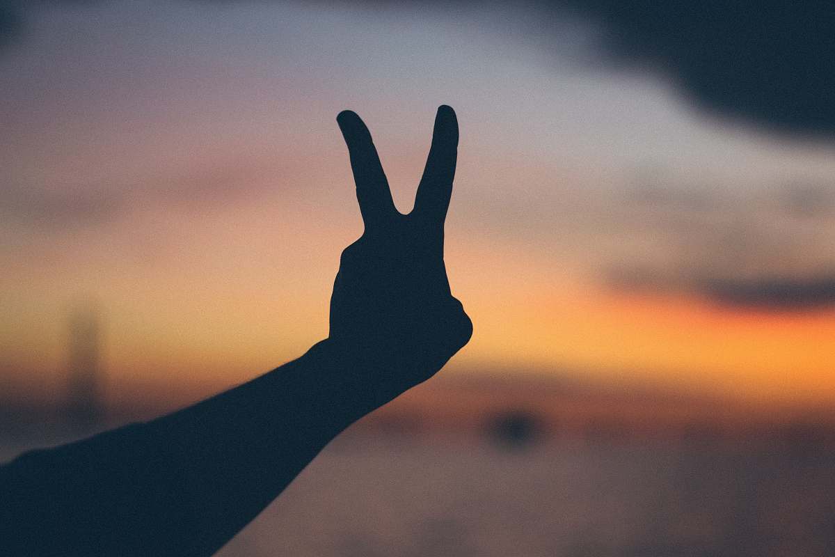 peace silhouette photography of right person's hand doing peace hand gesture mackinac island