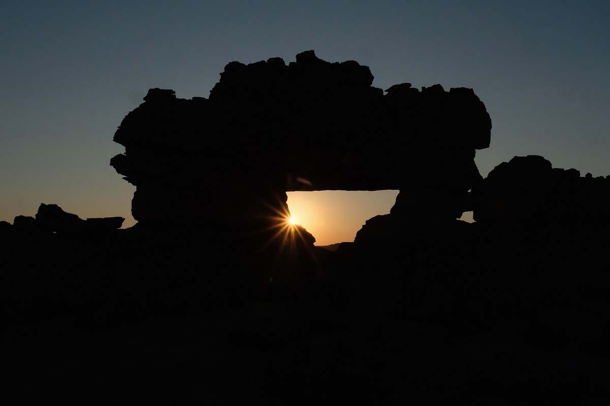 sunlight silhouette photography of rock formation during golden hour leisure activities