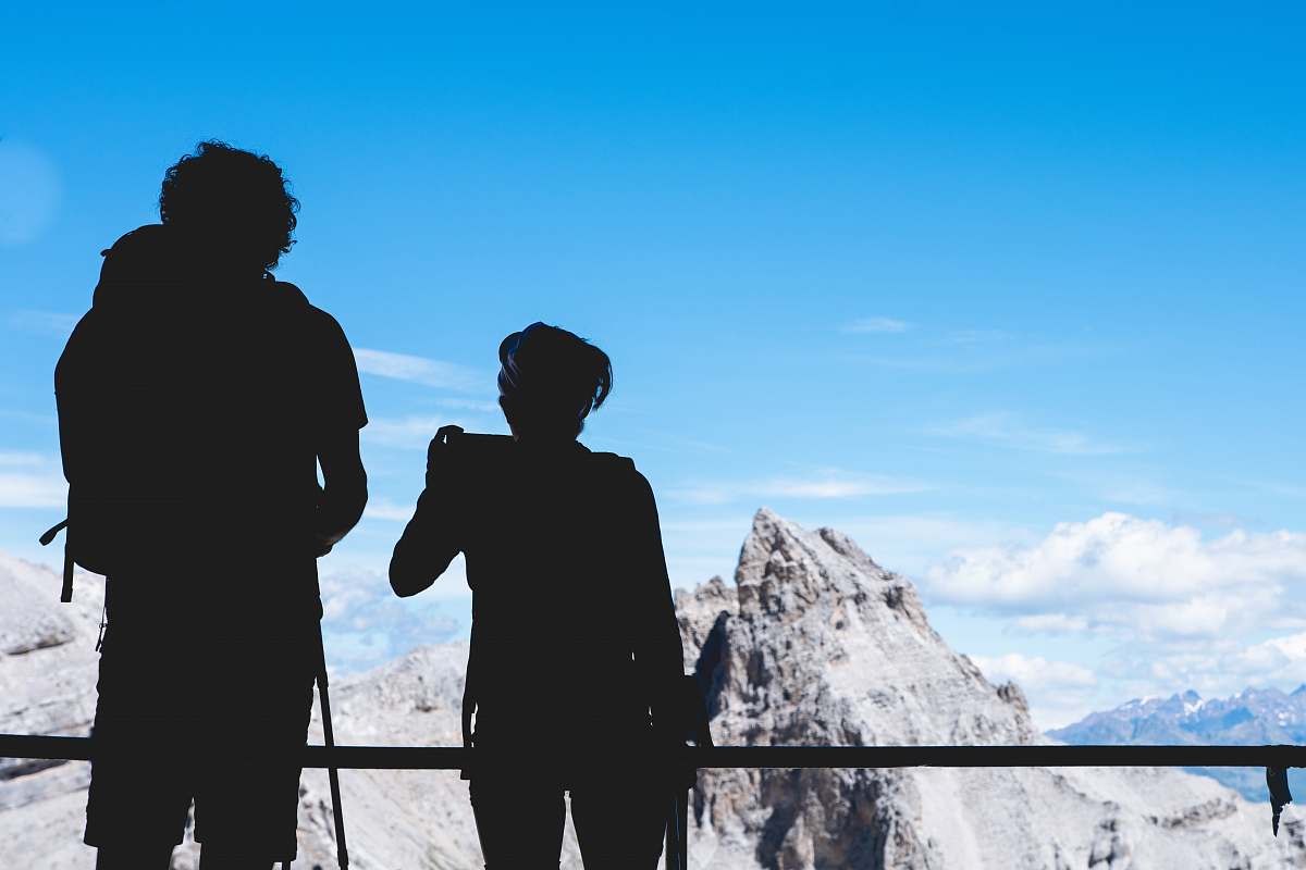 human silhouette photography of two person standing on top under clear blue sky people