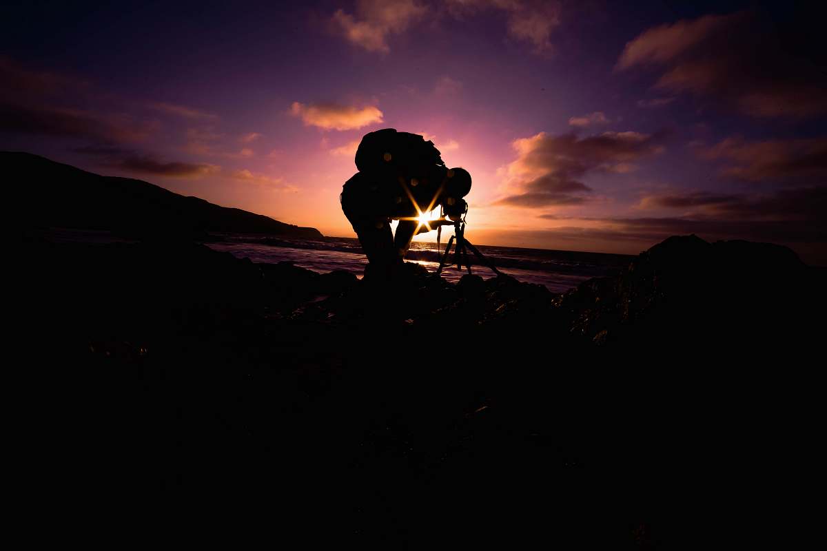 sunset silhouette view of man bending under golden hour sunrise