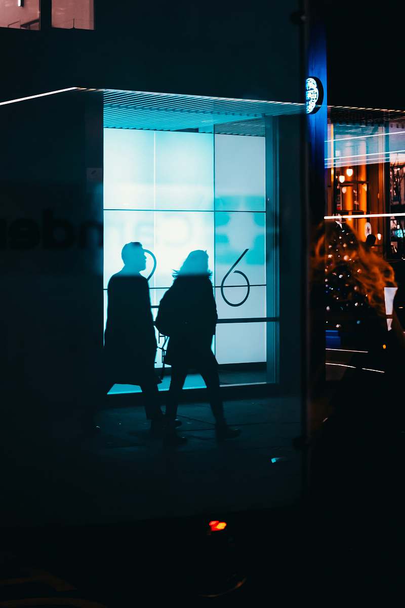 night silhoutte of man and woman walking london