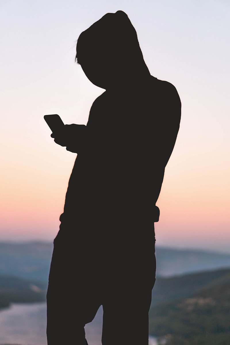 human silhoutte of person using smartphone person