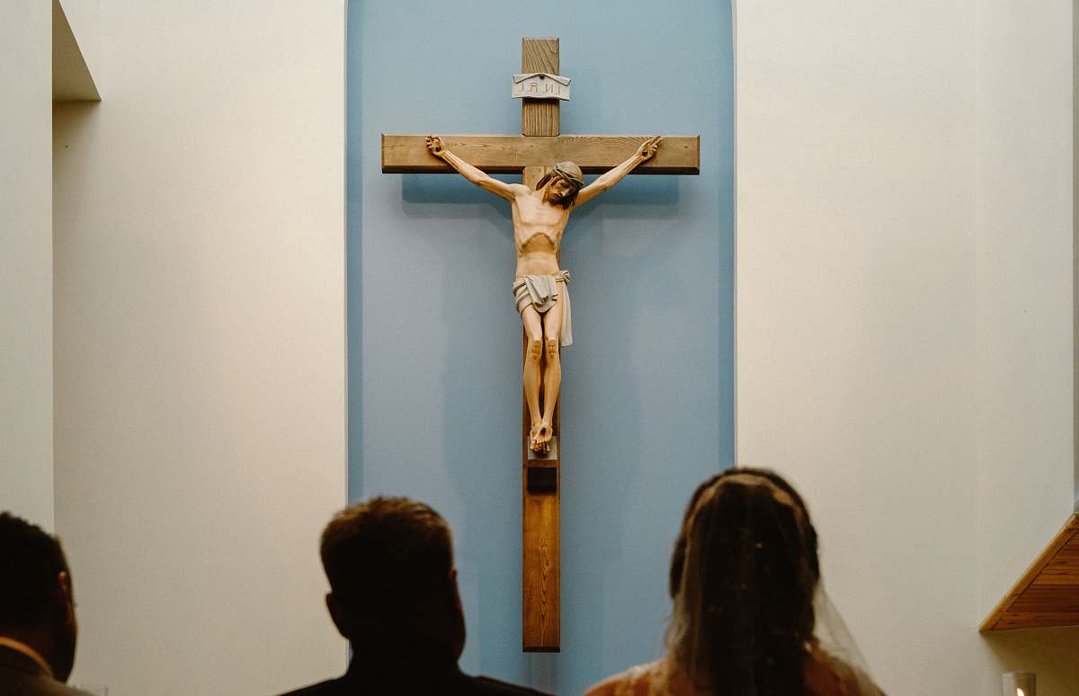 emblem three people staring at the crucifix crucifix