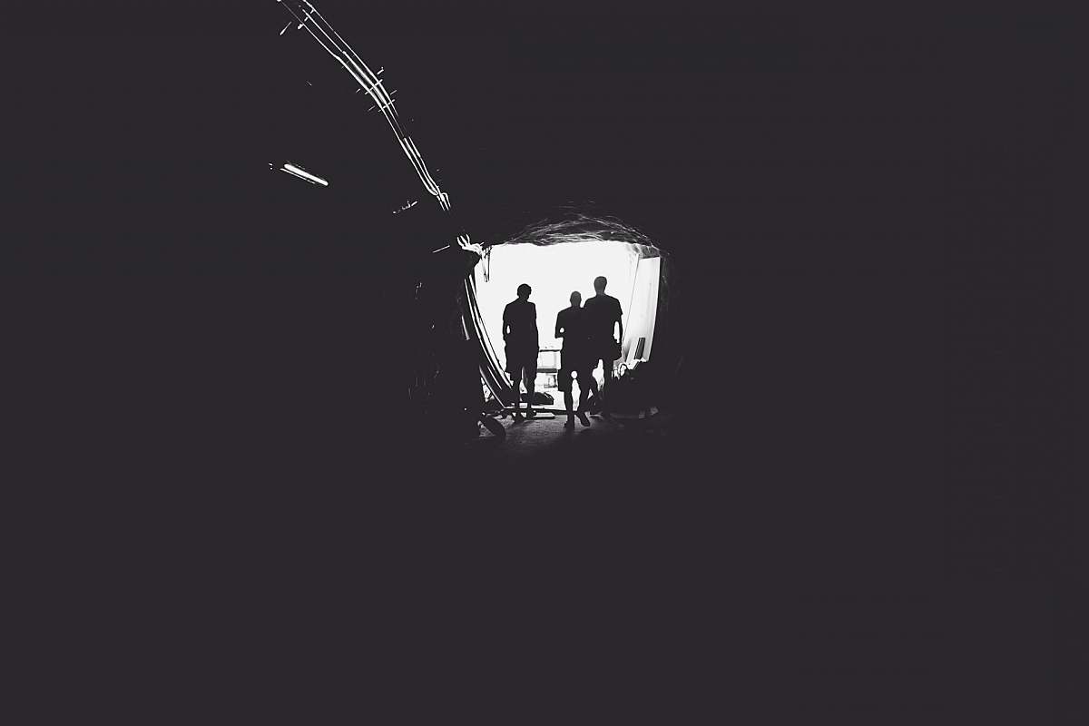 black-and-white three person standing in tunnel tunnel