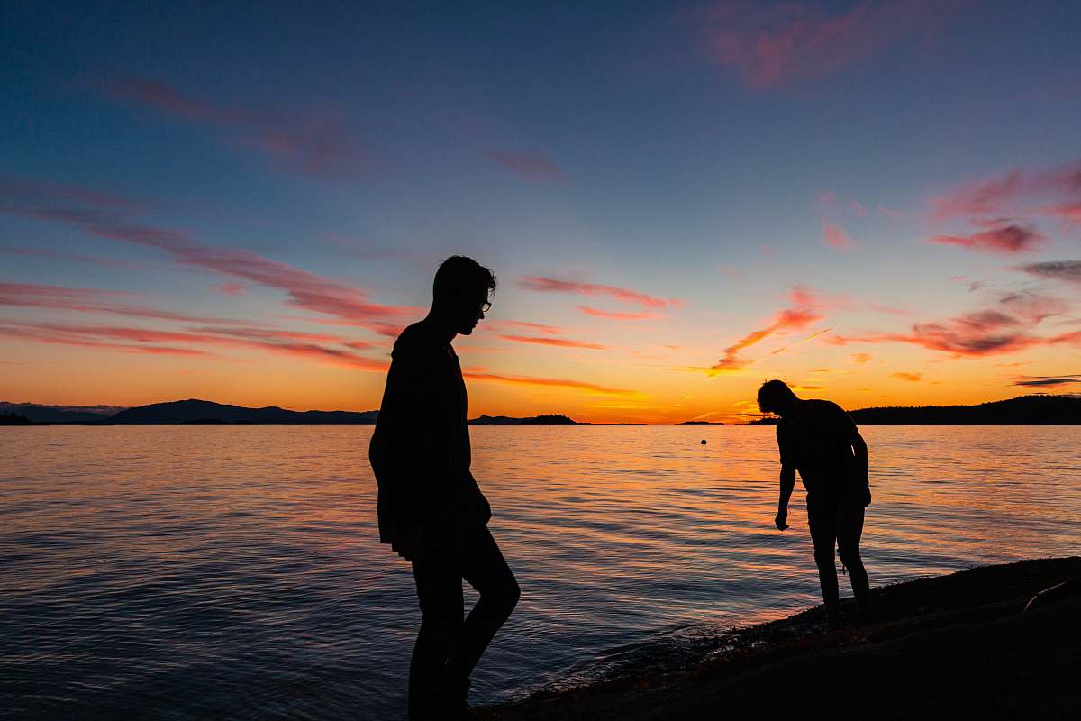 person two men standing beside body of water human