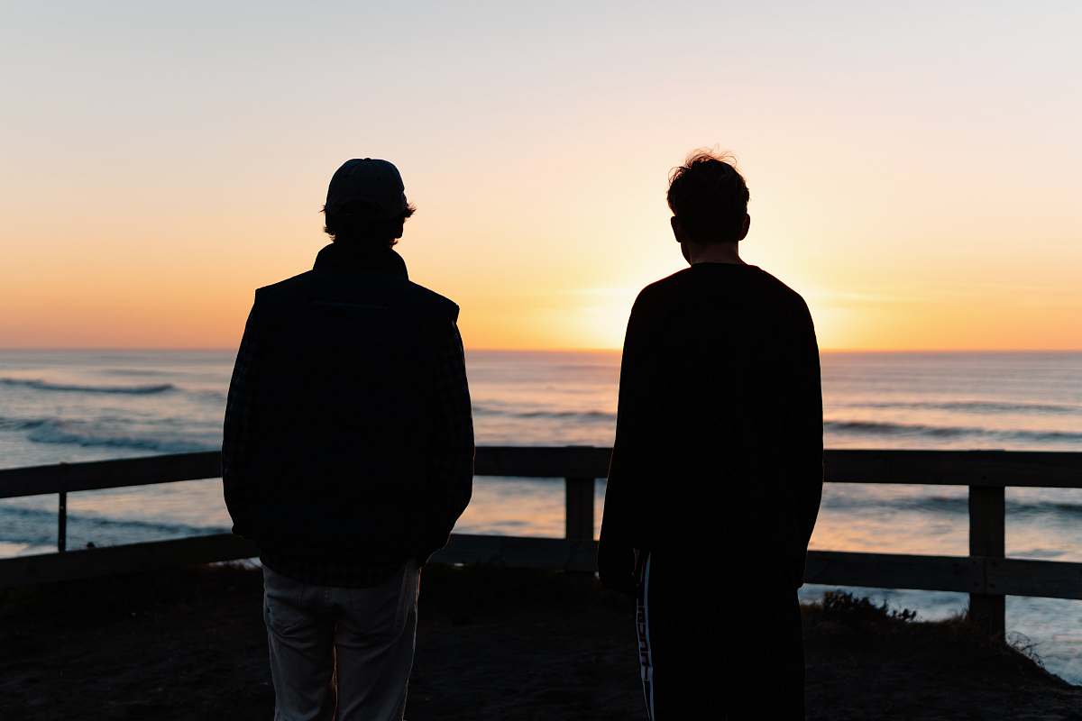 person two men standing beside sea human