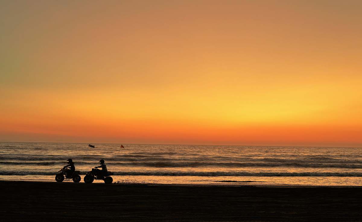nature two person riding ATV's during golden hour outdoors