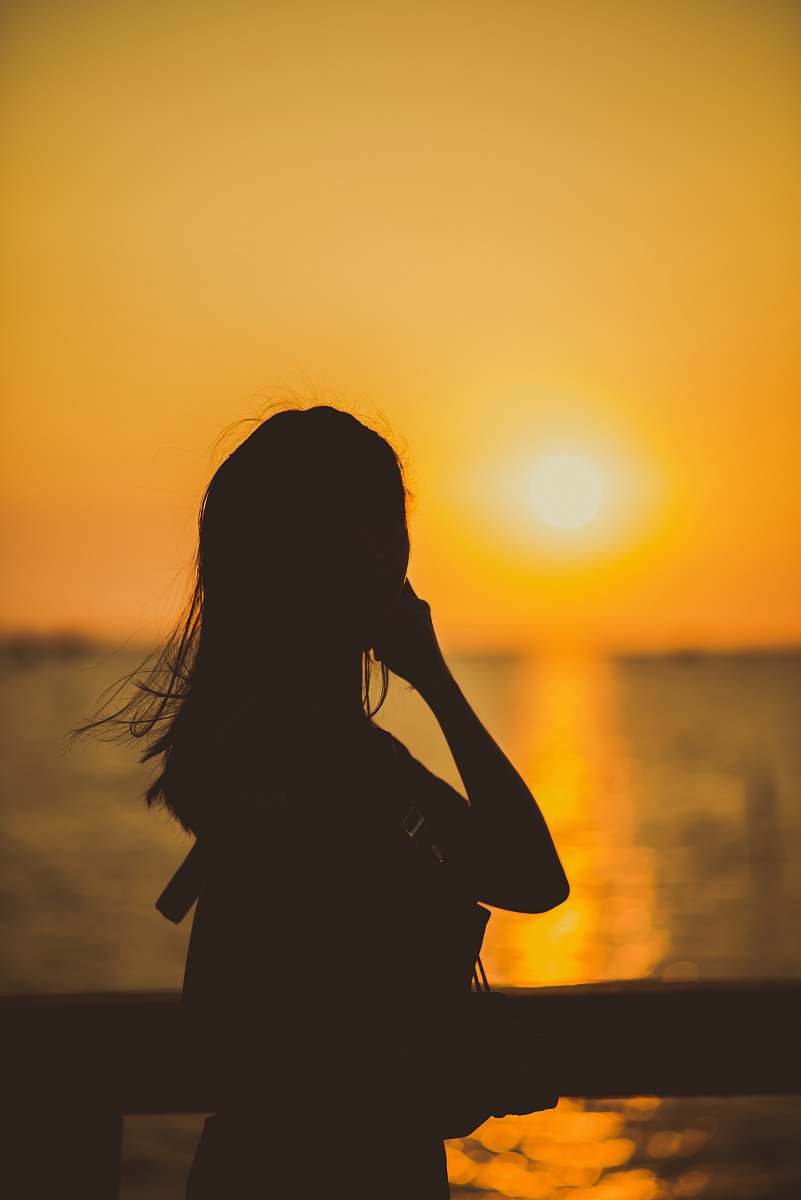 person woman beside railing during golden hour human