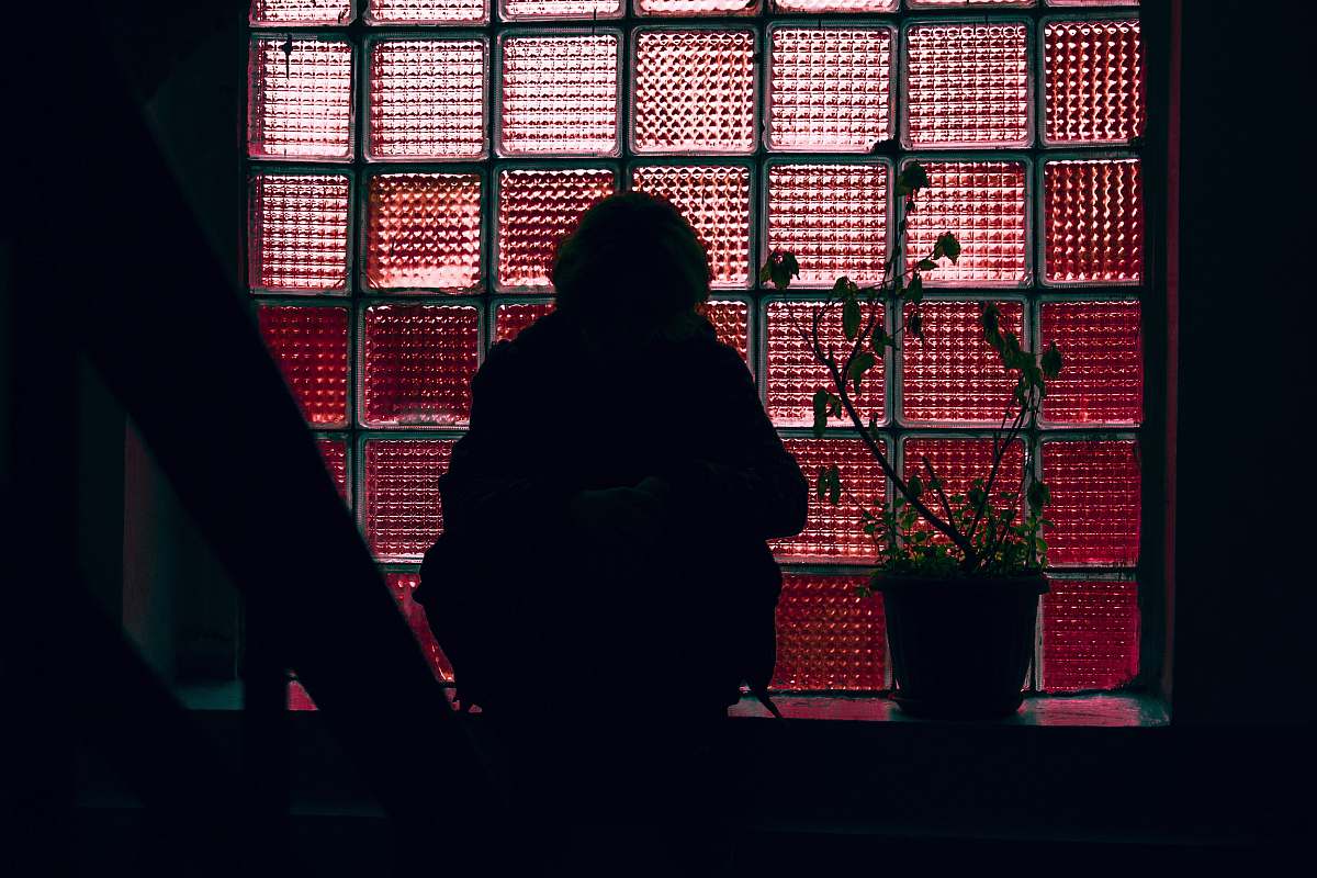 human woman sitting in front of glass window panel lighting