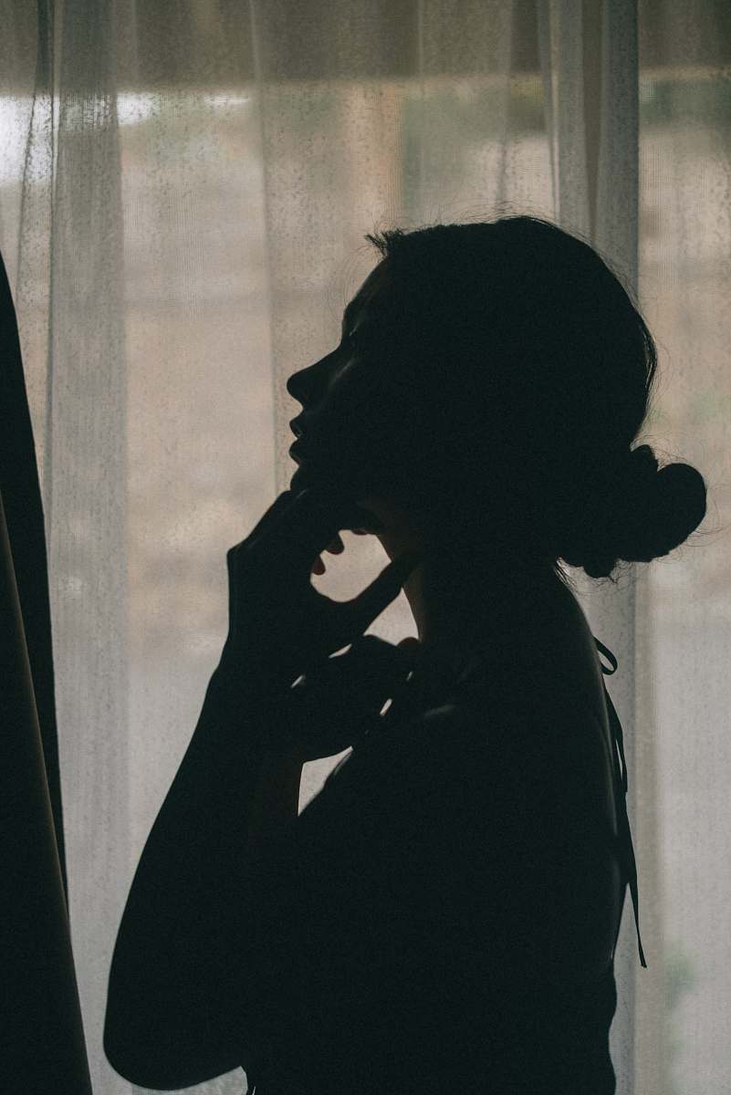 person woman touching her neck near window human