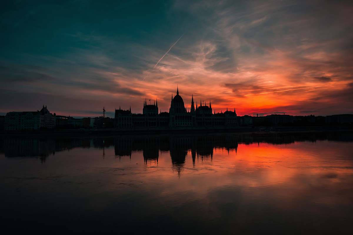 sunset silhouette of building under gray sky during golden hour sunrise