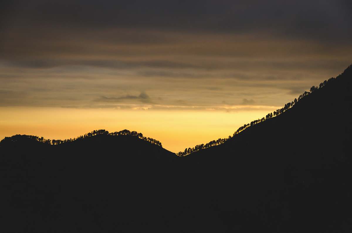 sunset silhouette of mountain with trees trees