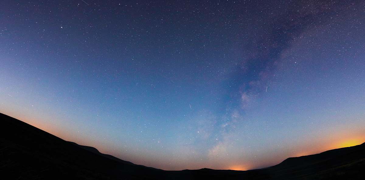 stars silhouette photo of mountain celestial