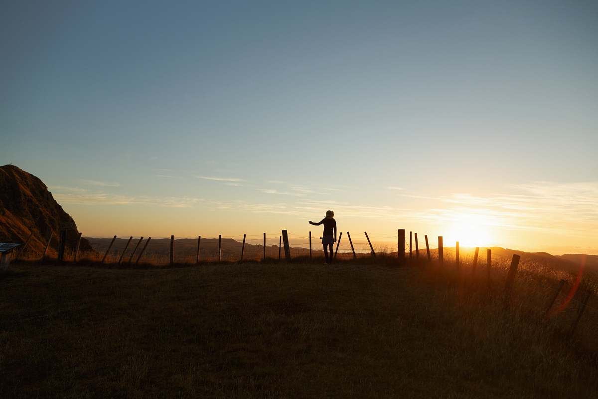 silhouette silhouette of man standing in the middle of field facing sunset nature
