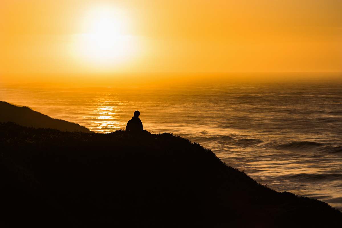 sunset silhouette photography of man walking hill