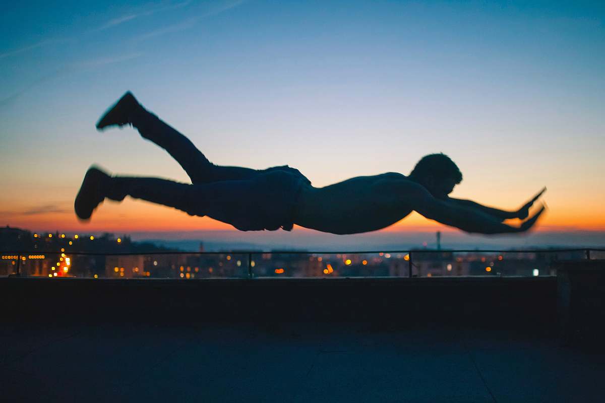 falling gray scale photo of man falling during golden hour levitation