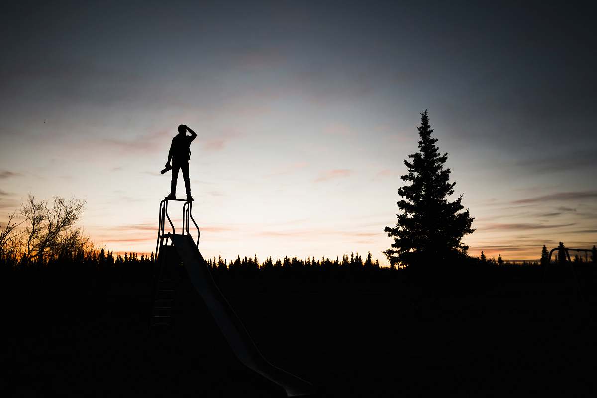 silhouette silhouette of a person standing on frame near tree during sunset man
