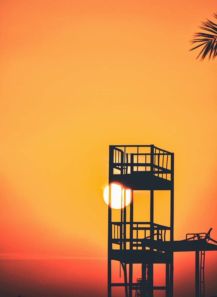 sunrise silhouette of watch tower during golden hour orange